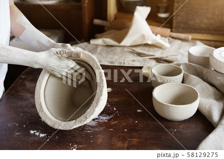 Female hands hold a bowl for casting clay products.  58129275