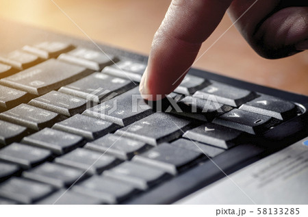The man's hand is in the index finger and press the Enter button on the keyboard. The man's hand is in the index finger and press the Enter button on the keyboard. 58133285