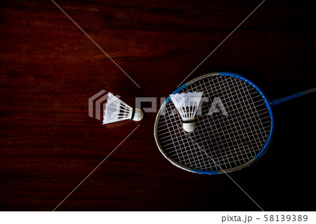 The still life badminton shuttlecocks feather and racket with wooden table color background.  58139389