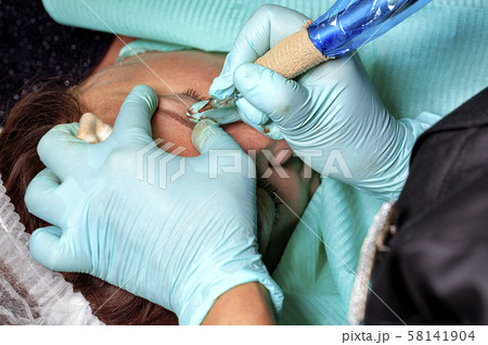 Master makes hardware eyebrow tattoo for ladie. Master makes hardware eyebrow tattoo for ladie. 58141904