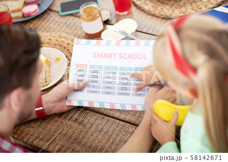 Daughter bringing her schedule to daddy before heading to school Daughter bringing her schedule to daddy before heading to school 58142671