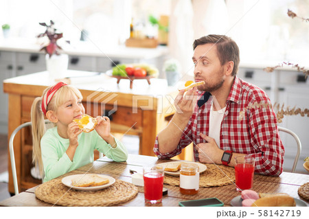 Daddy and his lovely girl eating yummy morning toasts Daddy and his lovely girl eating yummy morning toasts 58142719