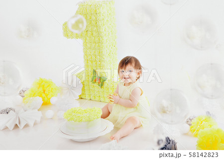 a little girl eats cake with her hands on the bacfground of fireplace. The baby was covered in food a little girl eats cake with her hands on the bacfground of fireplace. The baby was covered in food 58142823