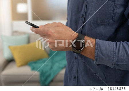 Young man at home using a smartphone Young man at home using a smartphone 58143873
