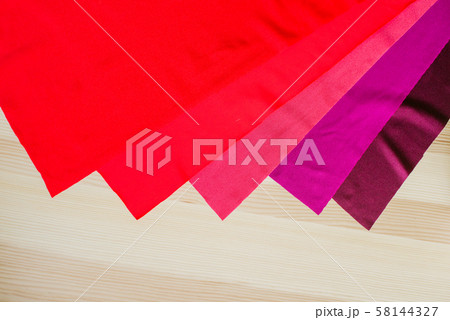 Bright multi-colored fabric cuts on a wooden background. Fabrics for sewing. Sewing materials Bright multi-colored fabric cuts on a wooden background. Fabrics for sewing. Sewing materials 58144327