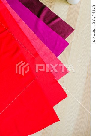 Bright multi-colored fabric cuts on a wooden background. Fabrics for sewing. Sewing materials 58144328