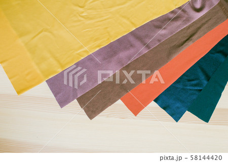 Bright multi-colored fabric cuts on a wooden background. Fabrics for sewing. Sewing materials Bright multi-colored fabric cuts on a wooden background. Fabrics for sewing. Sewing materials 58144420