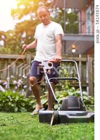 cutting overgrown grass with old fashioned lawn cutting overgrown grass with old fashioned lawn 58145674