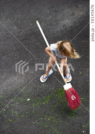Little girl helps her parents collect grass 58145676