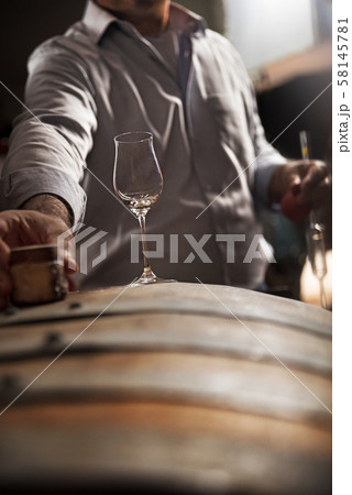 wooden barrel on a dark background, in a workshop wooden barrel on a dark background, in a workshop 58145781