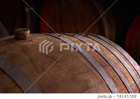 wooden barrel on a dark background, in a workshop wooden barrel on a dark background, in a workshop 58145789