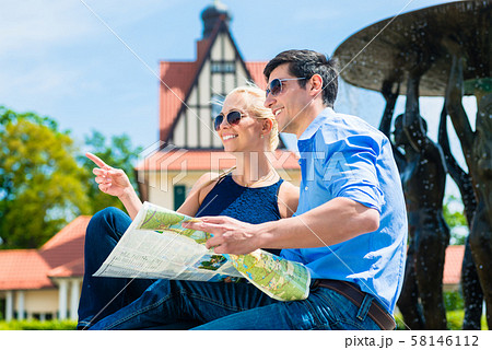 Smiling couple holding map 58146112