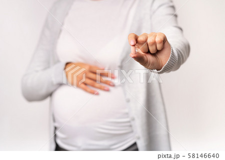 Pregnant Girl Showing Pill Touching Belly Over White Background, Cropped Pregnant Girl Showing Pill Touching Belly Over White Background, Cropped 58146640