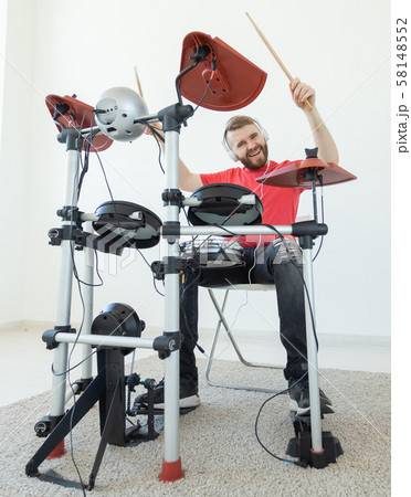 People, music and hobby concept - Tough man playing on electronic drum kit People, music and hobby concept - Tough man playing on electronic drum kit 58148552