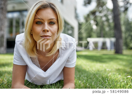 Beautiful young woman smiling at camera in a park outdoors. Outdoor recreation, happy life. Beautiful young woman smiling at camera in a park outdoors. Outdoor recreation, happy life. 58149086