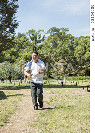 代々木公園でウォーキングをする中年男性 58154509