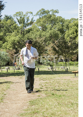 代々木公園でウォーキングをする中年男性 58154513