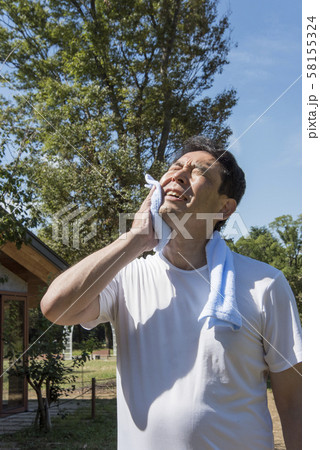 代々木公園で運動の後汗を拭く中年の男性 代々木公園で運動の後汗を拭く中年の男性 58155324
