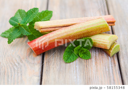 Fresh rhubarb and mint leaves on a wooden table 58155348