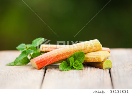 Fresh rhubarb with mint leaves on a wooden table 58155351