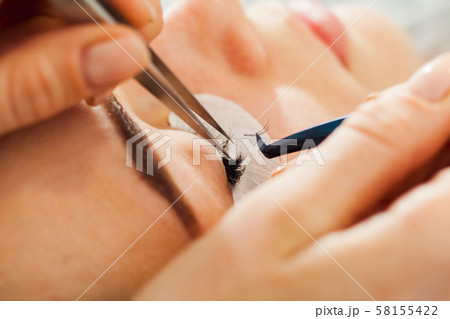 Woman Eye close up during the Eyelash Extension Woman Eye close up during the Eyelash Extension 58155422