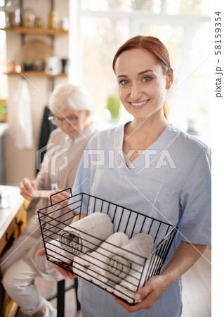 Personal caregiver smiling after washing towels 58159354