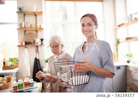 Medical attendant standing near pensioner wearing glasses 58159357