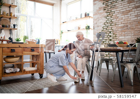 Hard-working caregiver lacing shoes for aged woman Hard-working caregiver lacing shoes for aged woman 58159547