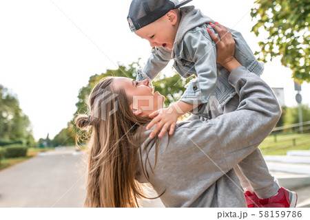 Young happy family smiling rejoicing having fun, mom throws up little boy 3-5 years old child, relax 58159786