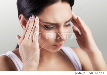 Headache in a young girl. Migraine. Fatigue after a hard working day. The concept of health. On a 58161444