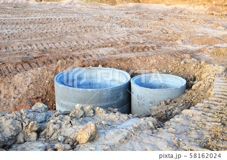 Installation of concrete sewer wells in the ground at the construction site.  58162024