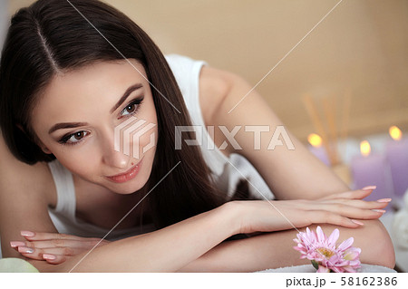 Beautiful young woman relaxing in jacuzzi hot tub at spa. Attractive female tourist is surrounded 58162386