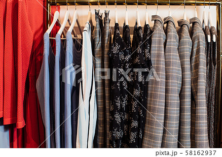 Close-up view of various stylish clothes hanging on hangers in boutique. Clothes Close-up view of various stylish clothes hanging on hangers in boutique. Clothes 58162937