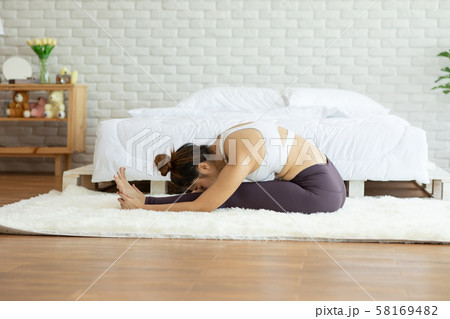 Happy Athletic Asian woman practice yoga stretching pose for stretching muscle for warm up with meditation smile after wake up in the morning Feeling so comfortable and relax,Healthcare Concept 58169482