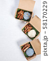 Sticky rice with grilled pork and fried pork put in a brown paper box 58170229