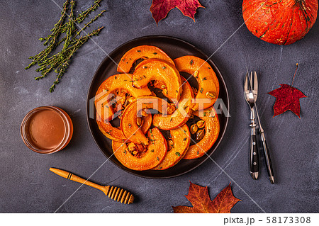 Baked slices of pumpkin on a dark background. 58173308
