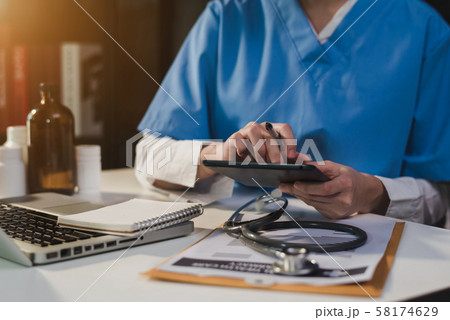Doctor working on desk with laptop computer and paperwork in the office. Medical and doctor concept. 58174629