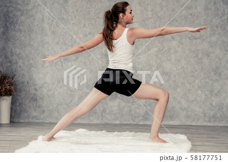 Young woman yoga on carpet at home living room. 58177751