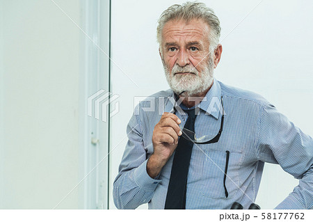 Senior man portrait hold eyeglasses in his hand. 58177762