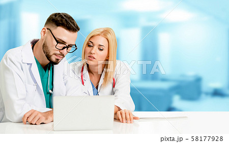 Doctors working with laptop computer in hospital. 58177928