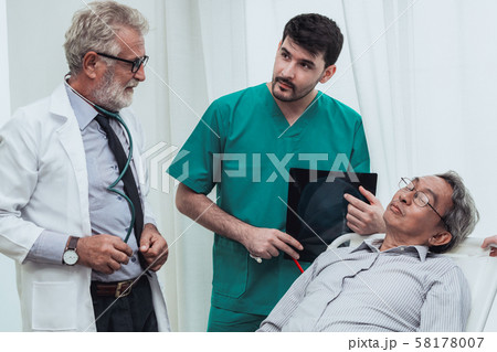 Doctor team work with x ray film image of patient. 58178007