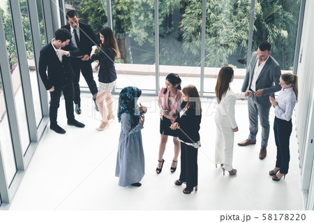 Many business people gathering in office building. Many business people gathering in office building. 58178220