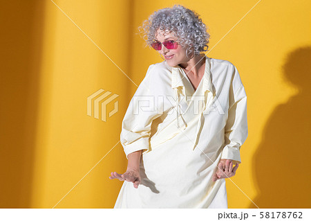 Mature woman wearing long dress moving and dancing 58178762