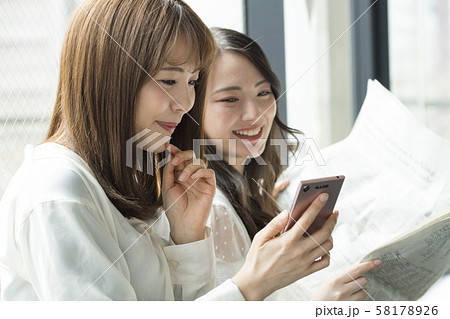 スマフォ　新聞　女性　二人 58178926