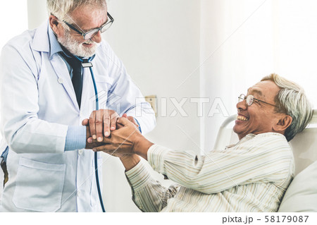 Mature doctor and senior patient in hospital ward. 58179087
