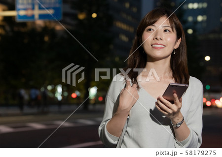 スマホを持つビジネスウーマン　丸の内 東京 都会 日本人女性 58179275