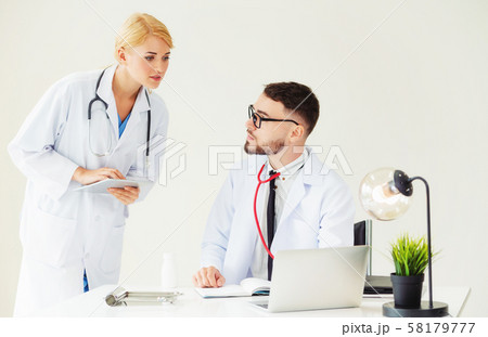 Doctor at hospital works on computer with partner. Doctor at hospital works on computer with partner. 58179777