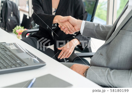 Businessman handshake businesswoman in office. Businessman handshake businesswoman in office. 58180199