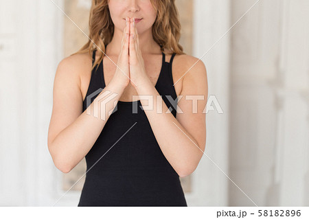 Closeup of young women holding her palm together on her chest 58182896