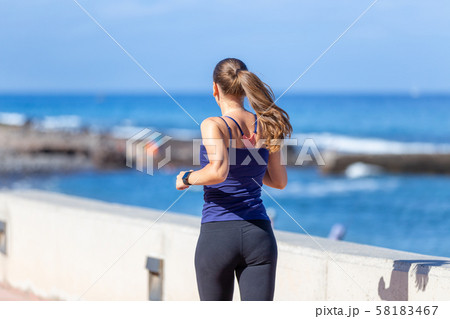 Young sporty woman jogging near the ocean 58183467